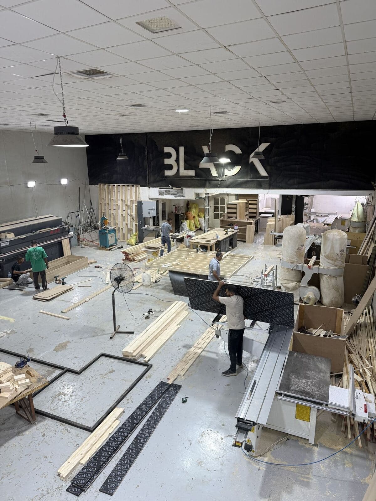 The factory floor with woodworking machines and the BLACK sign